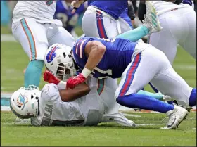  ?? David Santiago The Associated Press ?? Miami Dolphins quarterbac­k Tua Tagovailoa is sacked by Buffalo Bills defensive end A.J. Epenesa during first quarter of Buffalo’s
35-0 victory on Sunday. Tagovailoa left the game with a rib injury and did not return.