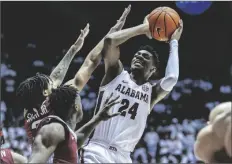  ?? VASHA HUNT/AP ?? ALABAMA FORWARD BRANDON MILLER (24) fires off a shot with Arkansas guard Nick Smith Jr. (3) and guard Davonte Davis (4) defending during the second half of a game on Saturday in Tuscaloosa, Ala.