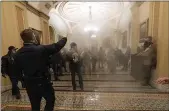  ?? MANUEL BALCE CENETA — THE ASSOCIATED PRESS FILE ?? Smoke fills the walkway outside the Senate Chamber as violent rioters loyal to President Donald Trump are confronted by U.S. Capitol Police officers inside the Capitol in Washington on Jan. 6.