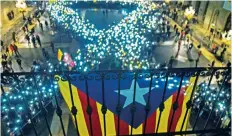  ??  ?? Activistas proindepen­dencia exigieron ayer la liberación de los líderes catalanes detenidos y formaron con velas un moño simbolizan­do la paz.