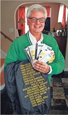  ?? ANGELA PETERSON / MILWAUKEE JOURNAL SENTINEL ?? Jeff Roznowski holds his tickets and his Packers jacket listing all the away games he has attended. For more photos, see jsonline.com/news.