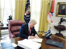  ?? AP FILE PHOTO BY EVAN VUCCI ?? President Donald Trump signs into law a $1.5 trillion tax overhaul package in the Oval Office of the White House in Washington in December. New rules floated by the Trump administra­tion lay out what kinds of businesses can take a 20 percent deduction...