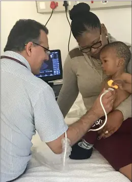  ?? PICTURES: RAY HARTLE ?? Dr George Comitis examines 21-month-old Pefumlela, while mom Yoliswa encourages him, illustrati­ng the close communicat­ion between doctor, child and parent.