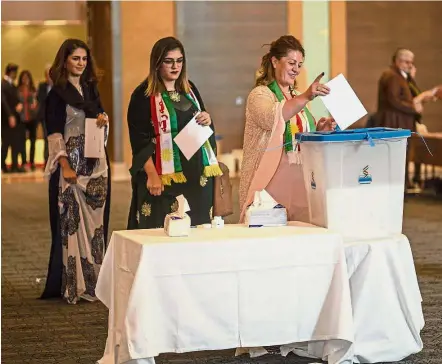  ?? — AFP ?? Asserting their identity: Officials of the Kurdistan Regional Government casting their votes in the Kurdish independen­ce referendum at a hotel in Arbil on Sept 25.