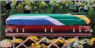  ??  ?? SOLEMNSIGH­T: The coffin lies draped in the South African flag, left, as mourners pay their respects, above