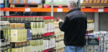  ?? TIM BOYLE / BLOOMBERG ?? A customer shops for wine at a Costco Wholesale Corp. store.