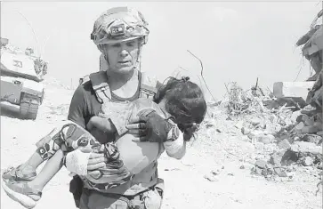  ?? Free Burma Rangers ?? DAVID EUBANK, who heads a volunteer group, plucked a girl to safety in Mosul, Iraq. Obscured from snipers’ view by smoke from coalition forces, he and others crept up behind an advancing tank to reach the child.