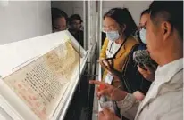  ?? PROVIDED TO CHINA DAILY The Orchid Pavilion Preface JIANG DONG / CHINA DAILY ?? From top: A guqin from the Southern Song period (1127-1279) on show. Wang Zilin, curator of the exhibition, introduces by Mi Fu to visitors.