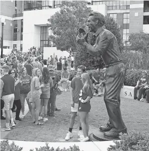  ?? MARVIN GENTRY/ USA TODAY SPORTS ?? Fans pose by the statue of Alabama football coach Nick Saban, erected in 2011, outside Bryant- Denny Stadium in 2017.