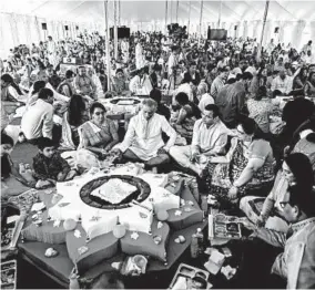  ?? SASHA MASLOV/THE NEW YORK TIMES 2016 ?? Families gather for a yagna, or ritual, in a large tent outside the Bochasanwa­si Shri Akshar Purushotta­m Swaminaray­an Sanstha Hindu temple, in Melville, New York.