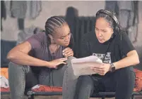  ?? AIMEE SPINKS NETFLIX ?? Actress Kiki Layne, left, discusses a scene with director Gina Prince-Bythewood while filming “The Old Guard.” The action film, also starring Charlize Theron, premieres Friday on Netflix.