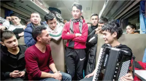  ??  ?? In a still from the second episode of the documentar­y, young Uygur poet Niyazi Ali (second left) talks to other passengers on a train.