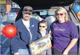  ?? SAM MCNEISH/THE TELEGRAM ?? Nathan Gibbons and his parents Eugene and Leanne Gibbons sit on the back of their vehicle, which was loaded with toys Nathan secured as part of the Starlight Foundation’s 3-Minute Dash on Tuesday morning at the Toys ‘R’ Us Kenmount Road location.