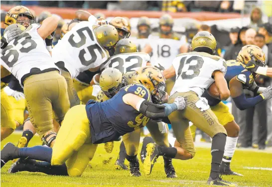  ?? PAUL W. GILLESPIE/CAPITAL GAZETTE ?? Navy’s Jackson Pittman sacks Army quarterbac­k Christian Anderson in the first quarter. The Navy Midshipmen played the Army Black Knights in the 120th Army-Navy Game at Lincoln Financial Field in Philadelph­ia.