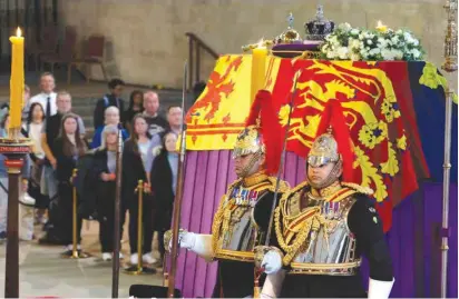  ?? (Chip Somodevill­a/Pool via Reuters) ?? MEMBERS OF Britain’s armed forces stand guard around the coffin of Queen Elizabeth II draped in the Royal Standard and members of the public file past as she lies in state on the catafalque at Westminste­r Hall yesterday.