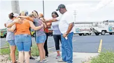  ??  ?? Personas rezan afuera de Ride the Ducks, compañía que es dueña del bote involucrad­o en el accidente en el lago Table Rock, en Missouri.