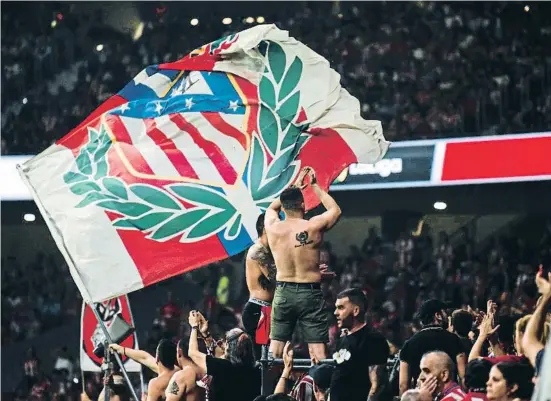  ?? NurPhoto / Getty ?? Un grup d’aficionats radicals de l’Atlètic fent onejar una bandera del seu equip durant el partit contra el Celta del 10 de setembre