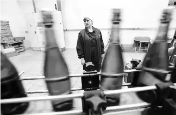  ??  ?? An employee stands as she works on the production line in the ‘Artwinery’ winery firm.