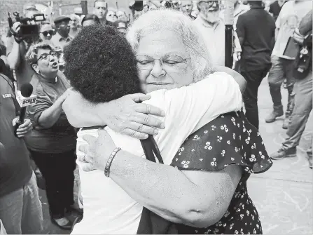  ?? WIN MCNAMEE ?? Susan Bro, mother of Heather Heyer, hugs a young woman near a memorial for her daughter, Heather, who was killed one year ago during a deadly clash in Charlottes­ville, Va.