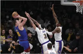  ?? MARK J. TERRILL – THE ASSOCIATED PRESS ?? Nuggets center Nikola Jokic, who scored 35points, shoots as the Lakers' Anthony Davis, center, and Rui Hachimura defend on Saturday evening at Crypto.com Arena.
