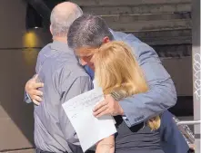  ?? ADOLPHE PIERRE-LOUIS/JOURNAL ?? Michael Riordan, center, shares a hug Sunday with friends outside Popejoy Hall before attending the memorial for his wife, Jennifer Riordan.