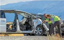  ?? MYTCHALL BRANSGROVE/STUFF ?? Two members of the serious crash unit inspect one of the vehicles involved in yesterday’s triple fatal.