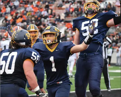  ?? PAUL DICICCO — FFOR THE NEWS-HERALD ?? Kirtland’s Mason Sullivan, center, celebrates with linemen Kiki Grman (50) and T.J. Green (52) after a touchdown in the Division V state final Nov. 21 against Ironton.