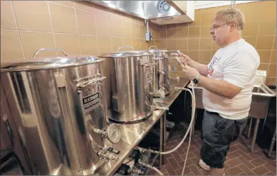  ?? AP PHOTO ?? Steve Clemens works on a batch of beer in his home basement brewery in Lodi, Wis. For many home brewers, having a dedicated space for brewing is both practical and fun and creating such a space requires some creativity.