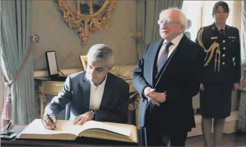  ??  ?? Mayor of London Sadiq Khan signs the visitor book at Aras an Uachtarain in Phoenix Park, Dublin alongside Irish President Michael D Higgins.