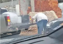  ??  ?? Los dos hombres en plena transferen­cia del alcohol de un bidón a otro, en una calle, a pocas cuadras del planta de Petropar.