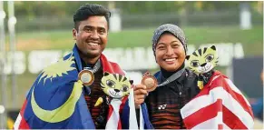  ??  ?? No golden glitter: Malaysian recurve archers Khairul Anuar Mohamed and Nur Aliya Ghapar posing with their medals at the National Archery Range in Bukit Jalil yesterday.