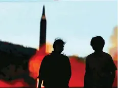  ?? — AFP ?? People walk in front of a monitor showing news of North Korea’s fresh threat in Tokyo on Thursday.