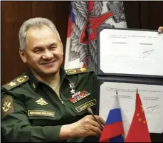  ?? ASSOCIATED PRESS ?? In this photo released by the Russian Defense Ministry Press Service, Russian Defense Minister Sergei Shoigu shows his signature under a roadmap for military cooperatio­n between Russia and China during a video call with Chinese Defense Minister Wei Fenghe in Moscow, Russia, Tuesday.