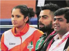  ?? PTI ?? Homecoming UAE Royal’s co-owner and Indian cricket team captain Virat Kohli with tennis star Sania Mirza watching the men’s doubles match in the New Delhi leg of IPTL.