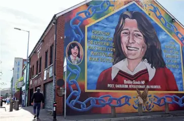  ??  ?? Photo ci-dessus : Belfast reste un véritable mausolée à ciel ouvert. Robert « Bobby » Sands (1954-1981), représenté sur cette fresque dans le quartier catholique de Falls, succombait, le 5 mai 1981, à 66 jours de grève de la faim à la prison deMaze, alors qu’il venait d’être élu député Sinn Féin à la Chambre des Communes, le 10 avril 1981. Son agonie a sensibleme­nt affecté le soft power internatio­nal de la Grande-Bretagne en matière de respect des droits de l’homme. ( © S.-C. Natale)