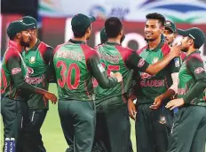  ?? Virendra Saklani/Gulf News ?? Bangladesh players congratula­te Mustafizur Rahman after the left-arm pacer dismissed Sri Lanka’s Suranga Lakmal.