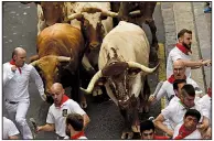  ?? AP/ALVARO BARRIENTOS ?? People take part in the bull run Sunday at the San Fermin Festival in Pamplona, Spain.