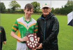  ??  ?? Kilcoole captain Charlie Frawley receives the trophy from referee Peadar De Hora.