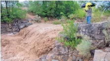  ?? EDDIE MOORE/JOURNAL ?? Aaron Hemmen of Santa Fe takes a video of the raging Santa Fe River after .4 of an inch of rain fell in an hour on Thursday.