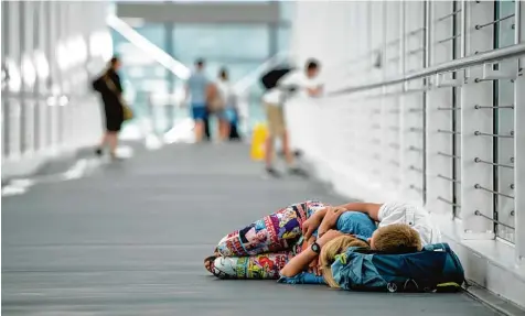  ?? Foto: Matthias Balk, dpa ?? Weil sie am Münchner Airport gestrandet waren, mussten viele Fluggäste dort auch übernachte­n. Einige legten sich einfach in einen der Gänge, andere schliefen auf Feld betten.