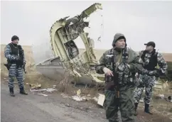  ??  ?? 0 Pro-russian gunmen guard the wreckage of flight MH17 in 2014