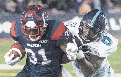  ?? GRAHAM HUGHES THE CANADIAN PRESS ?? Argonauts defensive lineman Tobi Antigha tackles Alouettes running back William Stanback on Friday night in Montreal.