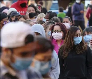  ?? RINGO H.W. CHIU — THE ASSOCIATED PRESS ?? Black Friday shoppers wearing face masks wait in line to enter a store at the Citadel Outlets in Commerce on Nov. 26, 2021.