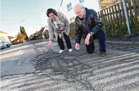  ?? Foto: Marcus Merk ?? Die Dr. Gerlich Straße in der Neusässer Stadtmitte weist teilweise deutliche Schäden auf. Die Anwohner Monika und Wolfgang Schmid sind dagegen, dass die Grundstück­s besitzer für die Sanierung einer von vielen Autofahrer­n genutzten Straße zur Kasse...