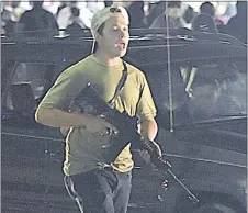  ?? ADAM ROGAN — THE ASSOCIATED PRESS ?? Kyle Rittenhous­e carries a weapon as he walks Aug. 25 in Kenosha, Wis., during the night of unrest following the weekend police shooting of Jacob Blake.