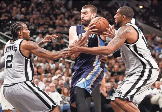  ?? SOOBUM IM/USA TODAY SPORTS ?? Grizzlies center Marc Gasol drives to the basket as Spurs small forward Kawhi Leonard and LaMarcus Aldridge, right, defend during Game 1 of their first-round playoff series on Saturday in San Antonio. The Spurs won 111-82.