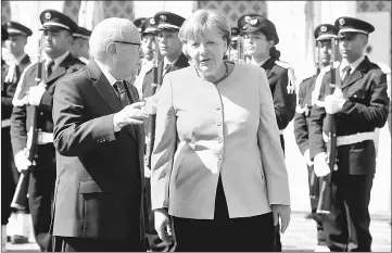  ??  ?? Essebsi (left) and Merkel speak as they review the honour guard upon her arrival in Tunis. — AFP photo