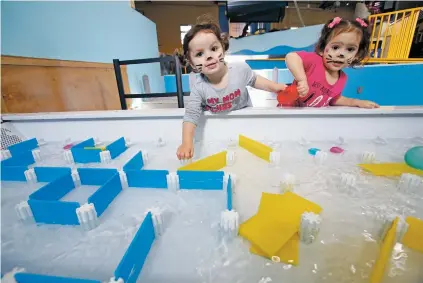  ??  ?? ABOVE: Cousins Nevaeh McDonnald, left, and Annali Perez, both 2, play on the water flow table at the Santa Fe Children’s Museum. A group of parents donated the $29,000 table, which lets children use plastic tiles to build dams and channel the water.