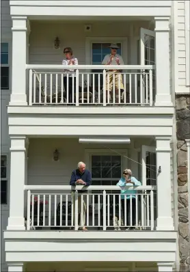  ?? DANA JENSEN/THE DAY ?? Residents of StoneRidge, a senior living community in Mystic, watch from their balconies a performanc­e by members of the Top Hat and Tails club on May 16.