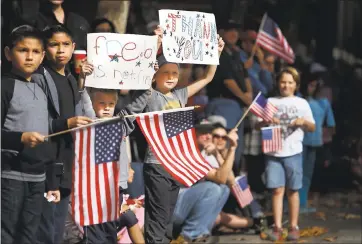  ?? STAFF FILE PHOTO ?? John Henry Kirchenbau­er, 6, and his sister, Kate Kirchenbau­er, 9, of San Jose, hold messages for veterans during San Jose’s annual Veterans Day parade in downtown San Jose in 2014.